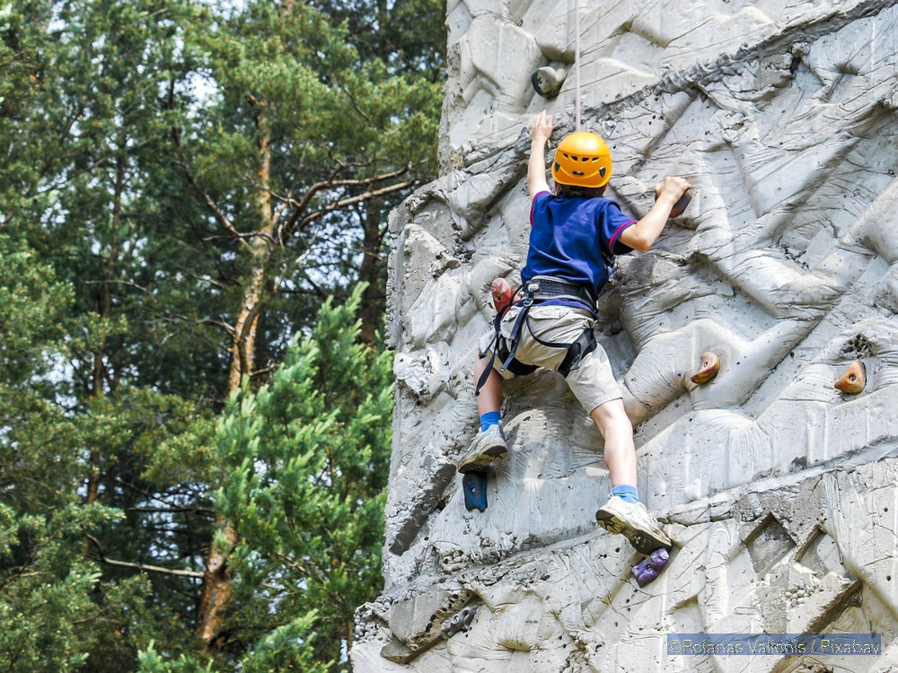 Kind klettert an Kletterwand